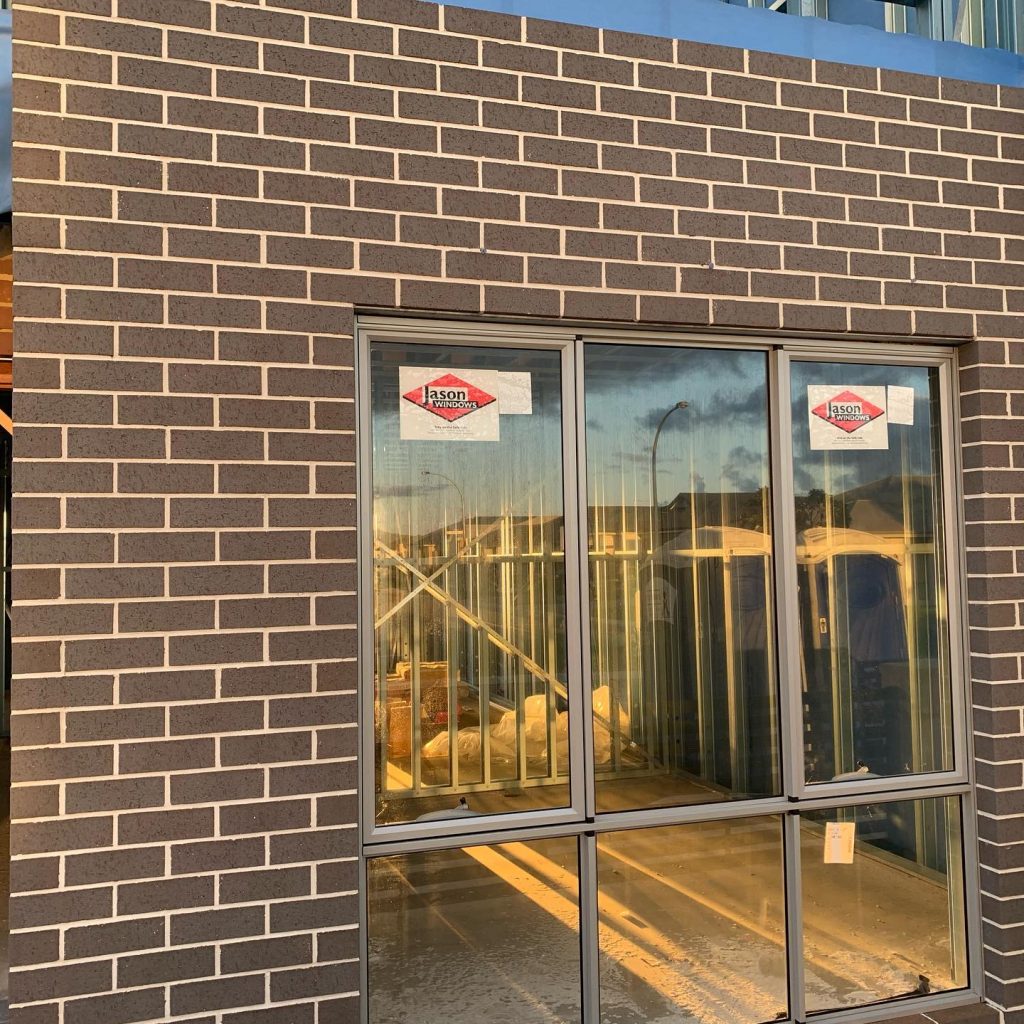 Charcoal face brickwork wall with a clean window reveal, lit by late afternoon sun on an Aurora Bricklaying job in Perth